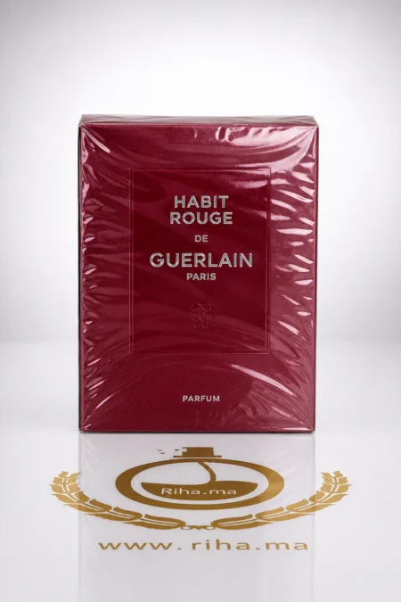 Flacon de habit rouge de guelain parfum posé sur fond rouge élégant